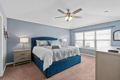 a blue bedroom with a bed and a ceiling fan at Modern Luxury 6 Bed Pool Home Close To Disney in Orlando