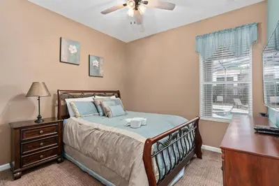 a bedroom with a bed and a desk and a window at Modern Luxury 6 Bed Pool Home Close To Disney in Orlando
