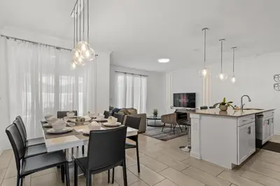 a dining room and living room with a table and chairs at Modern design near Disney Top resort in Kissimmee
