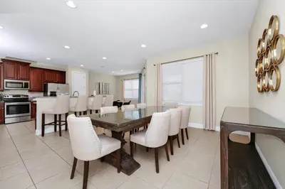 a kitchen and dining room with a table and chairs at Spacious Home Near Disney With Game And Themed Rooms With Waterpark & Resort Access At Encore Resorts Reunion - 581La in Kissimmee