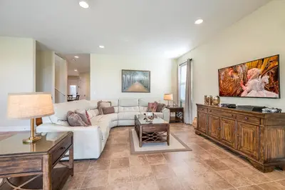 a living room with a white couch and a table at Lovely Home With Theme Rooms, Game Room With Waterpark & Resort Access Resort Access At Encore Resort- 7705By in Kissimmee