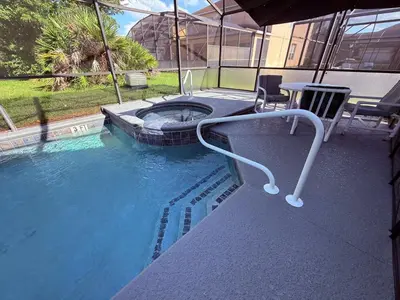a pool with a hot tub and chairs in the water at 201 HB - Hideaway at TerraVerde in Kissimmee