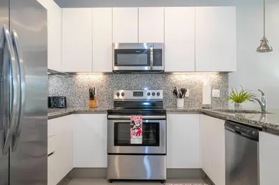 a kitchen with white cabinets and a stainless steel appliance at Charming 3Bd w Pool Close to Disney at Serenity 1639 in Orlando