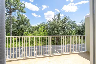 a balcony with a white fence and trees at Charming 3Bd w Pool Close to Disney at Serenity 1639 in Orlando