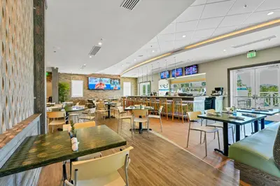 a restaurant with tables and chairs and a bar at Inviting Home Near Disney With Waterpark & Resort Access At Encore Resort - 7792Sw in Kissimmee