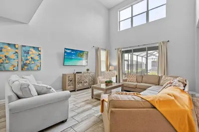 a living room with two couches and a window at 5 Bedroom 5 Bathroom Storey Lake 4760KC in Kissimmee