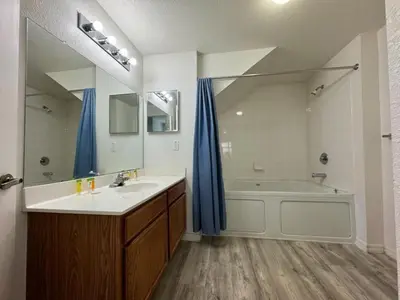 a bathroom with a tub and a sink and a mirror at 4 Bedroom 3 Bathroom Villas At Seven Dwarfs 8-107 in Kissimmee