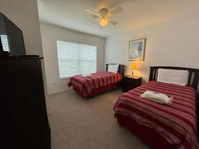a bedroom with two beds and a ceiling fan at 4 Bedroom 3 Bathroom Villas At Seven Dwarfs 10-102 in Kissimmee