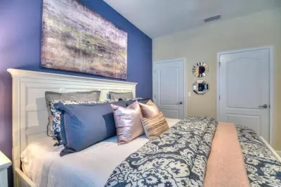 a bedroom with blue walls and a bed with pillows at 4 Bedroom 3 Bathroom Storey Lake 4895CT in Kissimmee