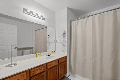 a bathroom with a sink and a shower curtain at 4 Bedroom 3 Bathroom Villas At Seven Dwarfs 24-102 in Kissimmee
