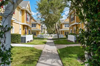 a walkway in front of apartment buildings at 4 Bedroom 3 Bathroom Villas At Seven Dwarfs 24-102 in Kissimmee
