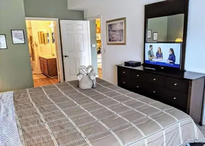 a bedroom with a bed and a flat screen tv at 4 Bedroom 3 Bathroom Villas At Seven Dwarfs 1-101 in Kissimmee