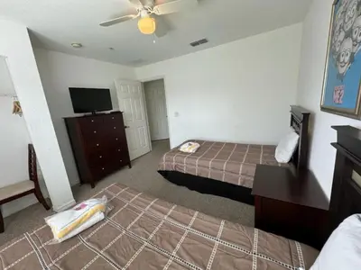 a hotel room with two beds and a flat screen tv at 4 Bedroom 3 Bathroom Villas At Seven Dwarfs 1-101 in Kissimmee