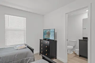 a bedroom with a bed and a dresser and a toilet at 3 Bedroom 3 Bathroom The Hub At Westside Reserve 3300 TT in Kissimmee