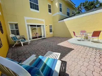 a patio with chairs and a table in front of a building at 3 Bedroom 3 Bathroom Terra Verde 4766 in Kissimmee