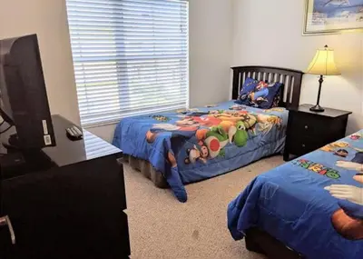 a bedroom with two twin beds and a window at 4 Bedroom 3 Bathroom Villas At Seven Dwarfs 8-108 in Kissimmee