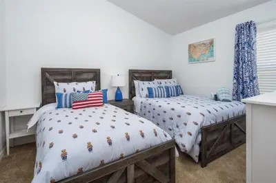 two beds in a room with white walls at 4 Bedroom Value Plus Home with Private PooI in Orlando