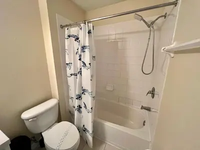a bathroom with a white toilet and a shower at Grand Emerald 3BR Condo Resort near Disney Parks in Kissimmee