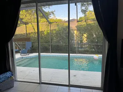 a view of a swimming pool through a window at Shrek's Hideout! - 5 min from Disney! in Kissimmee