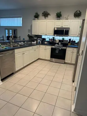 a kitchen with white cabinets and a tile floor at Shrek's Hideout! - 5 min from Disney! in Kissimmee