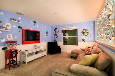 a living room with purple walls with a couch and a tv at Themed 5BD Home Movie and Game Room 4726 in Kissimmee