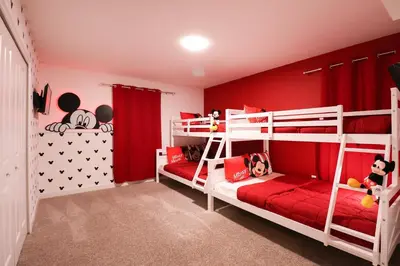 a bedroom with two bunk beds with red walls at Themed 5BD Home Movie and Game Room 4726 in Kissimmee