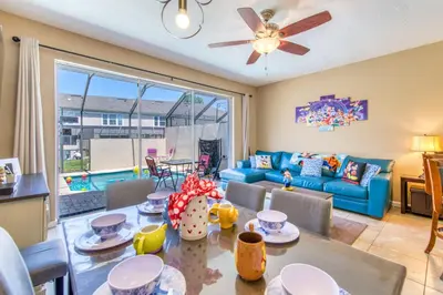 a living room with a blue couch and a table at Magical Getaway Close to Disney! Pool, Gym, & WiFi in Kissimmee