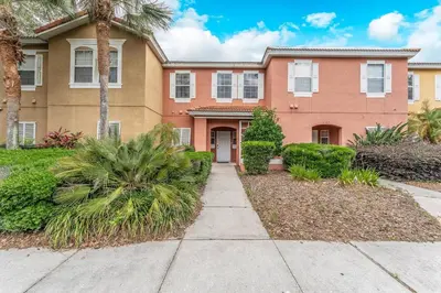 a house with palm trees and a sidewalk at Stay Close to Disney in Your 3-Bedroom Haven in Kissimmee