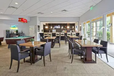 a restaurant with tables and chairs and a pool table at Stay Close to Disney in Your 3-Bedroom Haven in Kissimmee