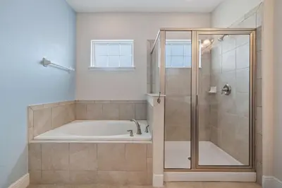 a bathroom with a tub and a glass shower at 7410 Marker Avenue in Orlando