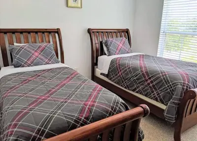 two twin beds sitting next to each other in a bedroom at 4 Bedroom 3 Bathroom Villas At Seven Dwarfs 17-107 in Kissimmee