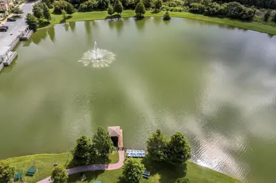 an aerial view of a large lake with a fountain at 4 Bedroom 3 Bathroom Villas At Seven Dwarfs 17-107 in Kissimmee
