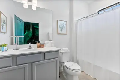 a white bathroom with a toilet and a sink at Brand NEW 12Bedrooms12Bathroom At Paradiso Grande in Orlando