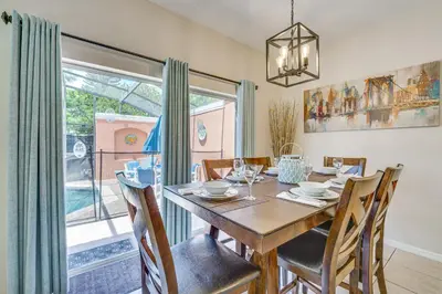 a dining room with a table and chairs and a window at 7 Mi to Disney Kissimmee Poolside Paradise! in Kissimmee