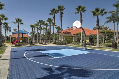 a basketball court in front of a house with palm trees at Private Pool Family-Friendly Kissimmee Townhome! in Kissimmee