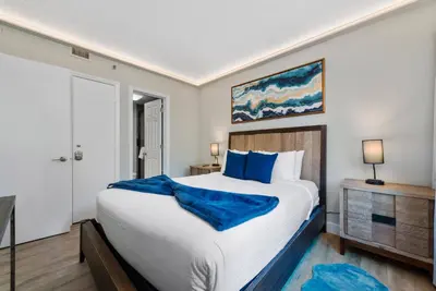a bedroom with a large bed with blue pillows at 2 Suites at The Enclave Near Universal in Orlando