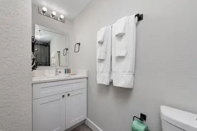a bathroom with white towels hanging on a wall at 2 Suites at The Enclave Near Universal in Orlando