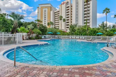 a large swimming pool with buildings in the background at 2 Suites at The Enclave Near Universal in Orlando