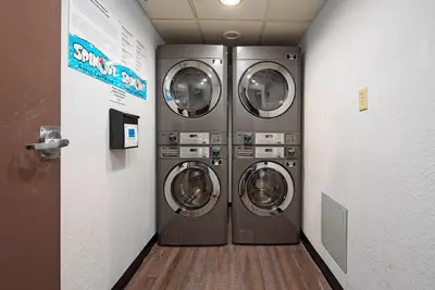 two washing machines in a laundry room with a hallway at 2 Suites at The Enclave Near Universal in Orlando