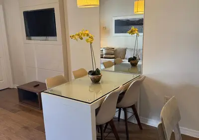 a dining room with a table with yellow flowers on it at The Point Hotel Apartment 603 Near to Universal in Orlando