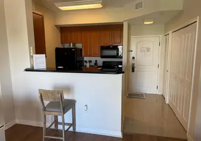 a kitchen with a bar and a chair in a room at The Point Hotel Apartment 603 Near to Universal in Orlando