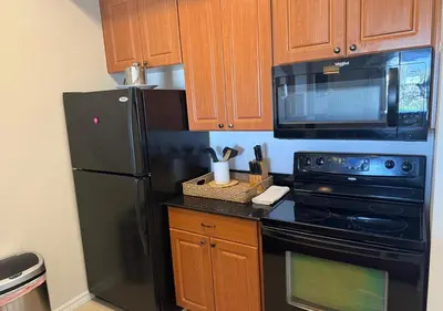 a kitchen with a black refrigerator and a microwave at The Point Hotel Apartment 603 Near to Universal in Orlando