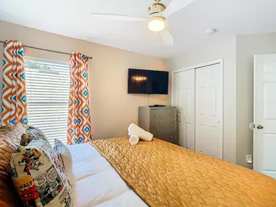 a bedroom with a bed and a flat screen tv at WH7742CS - Newly renovated villa in Windsor Hills in Orlando