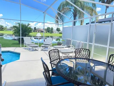 a patio with a table and chairs and a pool at EP1051SEL - Private Vacation Pool Home Near Disney in Kissimmee