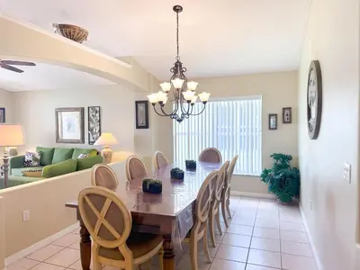 a dining room and living room with a table and chairs at EP1051SEL - Private Vacation Pool Home Near Disney in Kissimmee