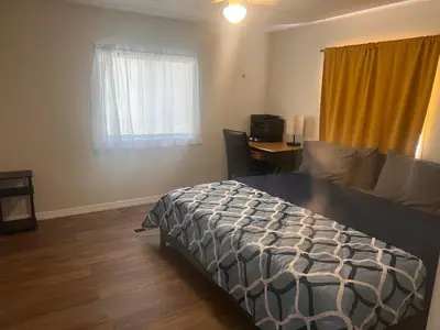 a bedroom with a bed and a desk and a window at Mobile Home on huge parking space 10 mins from airport, 20 mins from Disney in Kissimmee