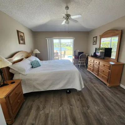 a bedroom with a bed and a dresser and a television at 4 Bedroom villa in Lake Berkley, Private Pool Fantastic View, Free WiFi, Theme Parks All Around! in Kissimmee