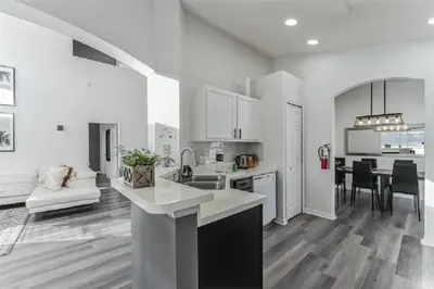 a white kitchen and living room with a counter top at 637- Huge 5 Bed Villa with Amazing Water Views and Own Private Pool and Spa in Kissimmee
