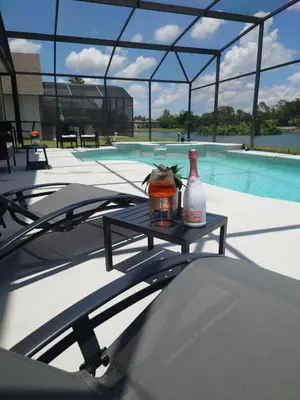 a table with two bottles on top of a swimming pool at 637- Huge 5 Bed Villa with Amazing Water Views and Own Private Pool and Spa in Kissimmee