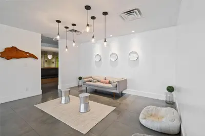 a living room with a couch and several mirrors on the wall at 11 Condo-Hotel With Double Bed And Community Pool Miles From Disney! in Kissimmee